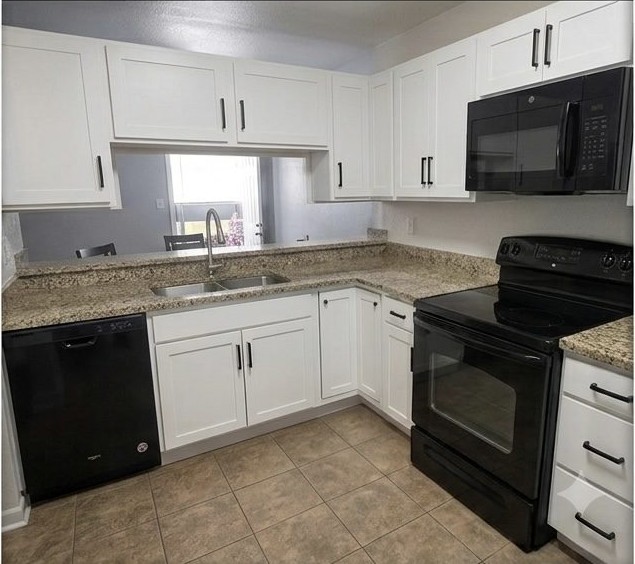 After: Lisa S.'s same Denver kitchen with white Shaker cabinet doors and black hardware, from her Google review photo.